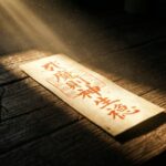 暗闇を切り裂く強い光に照らされる朱肉の護符。効果が出るまでの期間に訪れる激しい好転反応（瞑眩）や、運命が書き換わる前兆を象徴する画像です。